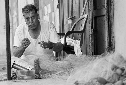 A fisherman mending nets at his home in Shati' camp. (2017, photo by the author)