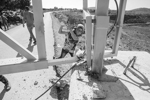 A young Palestinian in Dayr Nizam, a village near Ramallah, tries to break the padlock on a gate blocking the entrance of the village. The gate was installed by the Israeli army to curtail protests against the U.S. administration's Middle East “peace plan,” unveiled by the White House on 28 January. (15 February, Abbas Momani/AFP via Getty Images)